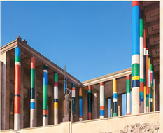 Portique d'un musée dont les colonnes sont habillées de bandes de couleurs