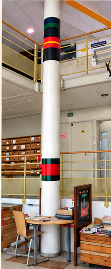 Colonne à anneaux colorés dans la bibliothèque, devant des rayonnages